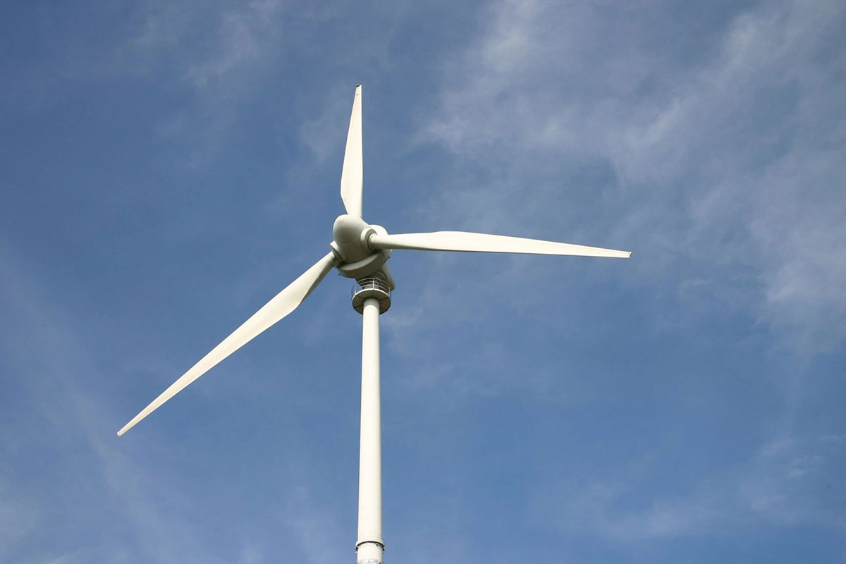 A wind turbine is shown against the blue sky.